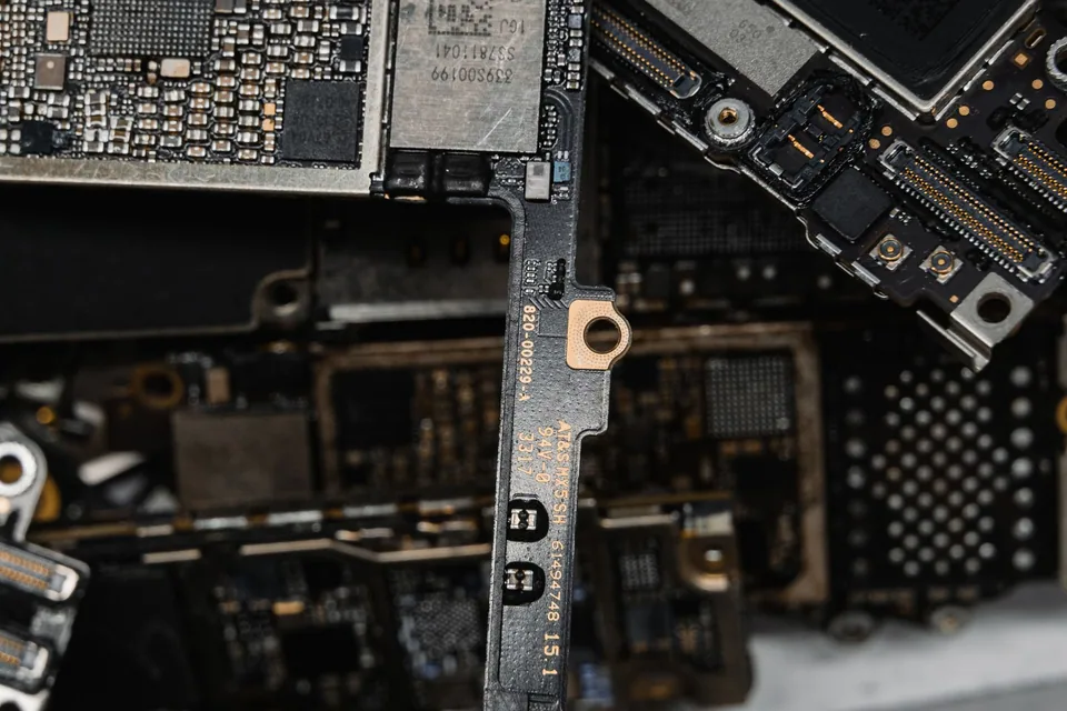 Placa de notebook desmontada, com conectores e trilhas visíveis em detalhe